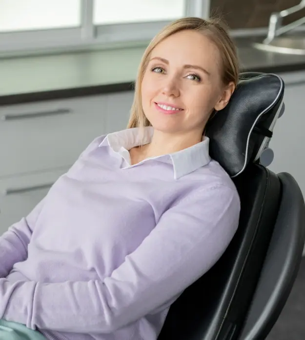 Welcoming female patient smiling in dental office chair at Lubbock practice.